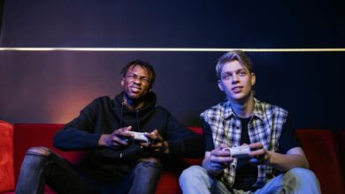 Two young men enjoying video games together on a couch, capturing leisure and friendship.