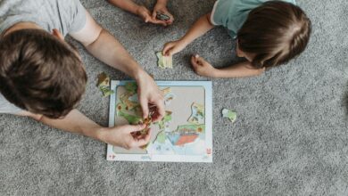 Father and children enjoying puzzle time together on a cozy carpeted floor.