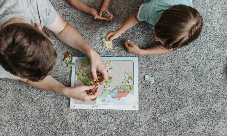 Father and children enjoying puzzle time together on a cozy carpeted floor.