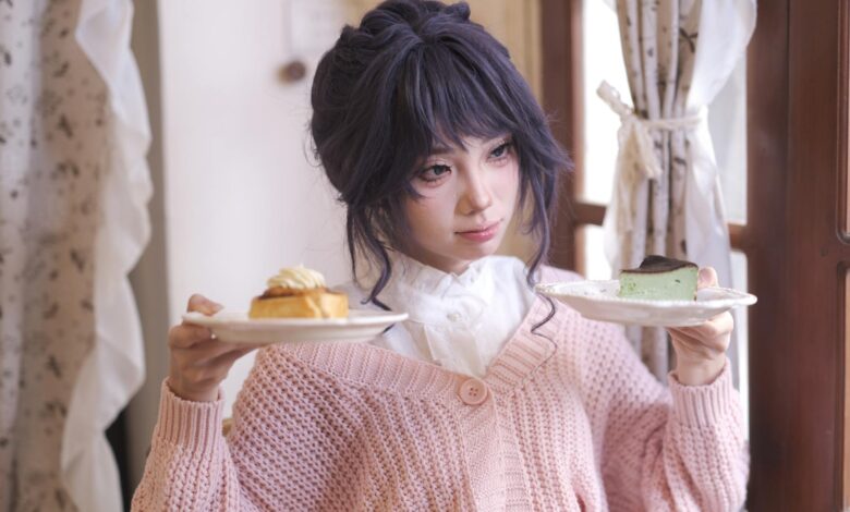 A young woman in a cozy setting holds plates with pastries, looking contemplative.