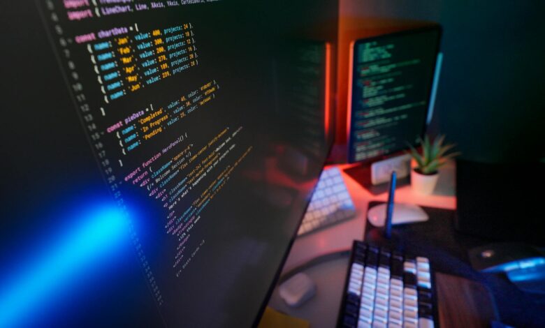 A vibrant workspace featuring colorful code on computer monitors, ideal for developers.