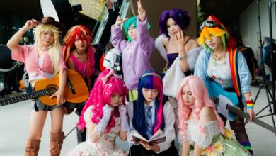 Vibrant group of cosplayers in anime costumes with musical instruments, showcasing diversity.