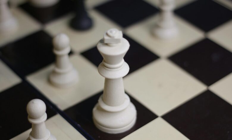 Detailed view of chess pieces on a chessboard, focusing on a king piece.