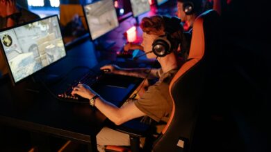 A group of gamers focused on a competitive match in a dimly lit esports arena.