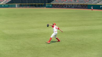 Athlete in action making a catch on green field in an empty stadium.