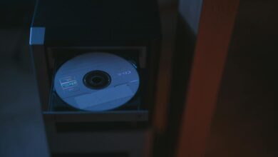 A close-up image of a CD partially ejected from a drive, showcasing soft lighting.