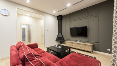 Interior of modern large living room with TV hanging on gray wall illuminated with bright lamps