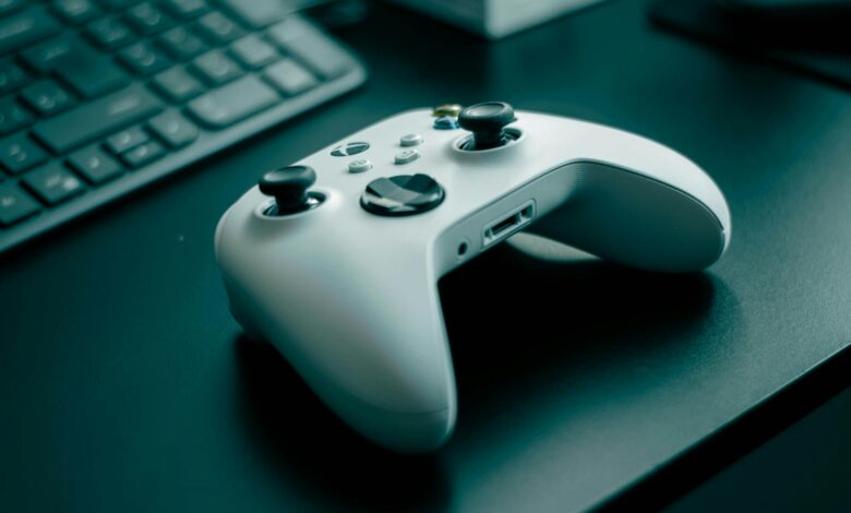 Close-up of a white game controller on a sleek desk, highlighting technology and gaming.