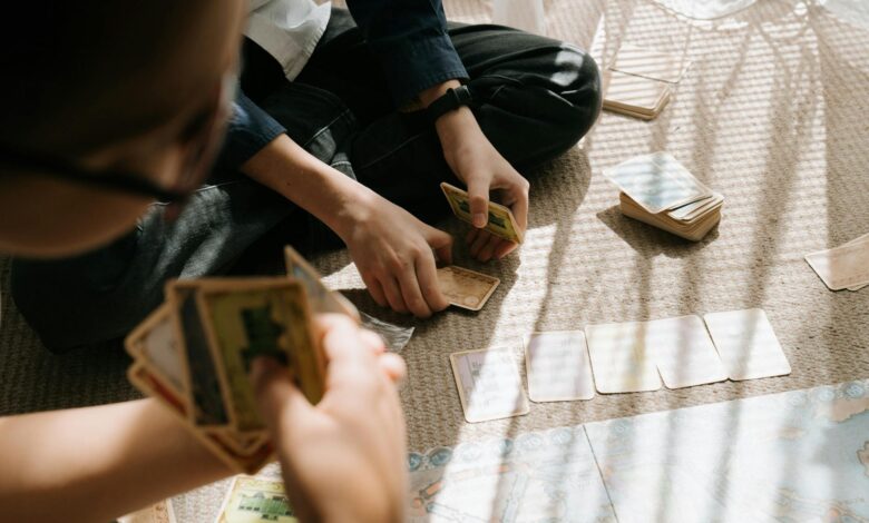 Kids engaged in an entertaining card game inside, with sunlight casting patterns on the floor.