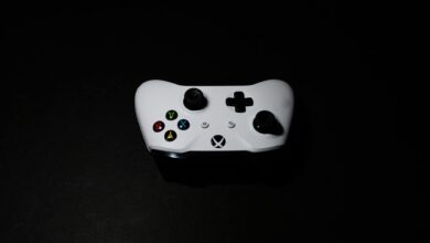 A close-up of a white Xbox controller on a black background, highlighting its modern design.