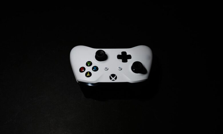 A close-up of a white Xbox controller on a black background, highlighting its modern design.
