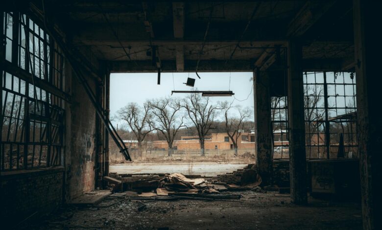 Atmospheric view from an abandoned building with broken windows and a moody sky.