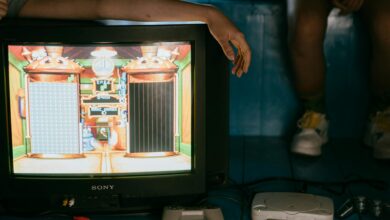 Crop unrecognizable female on modern monitor with video game on screen near ethnic partner