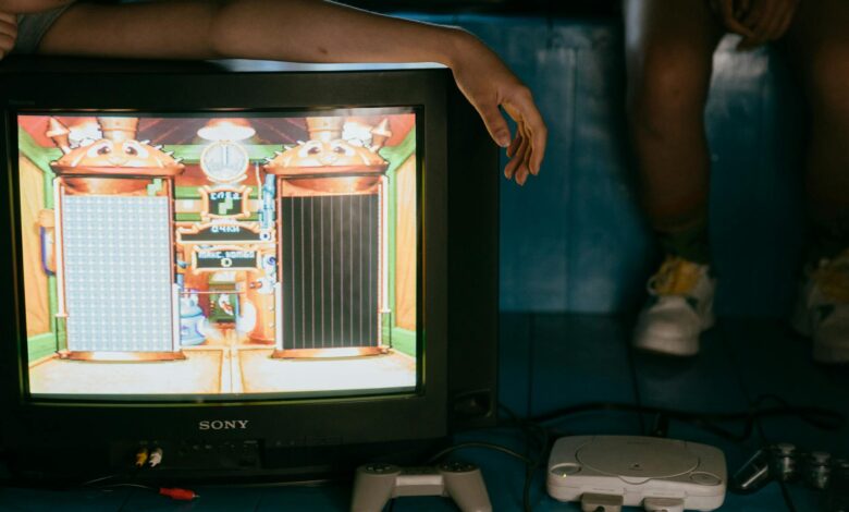 Crop unrecognizable female on modern monitor with video game on screen near ethnic partner
