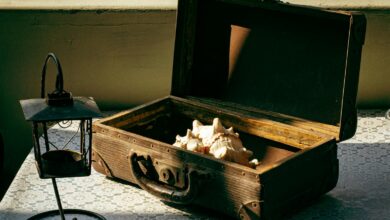Discover a rustic setup with a vintage box, shells, and lantern on a lace-covered table.