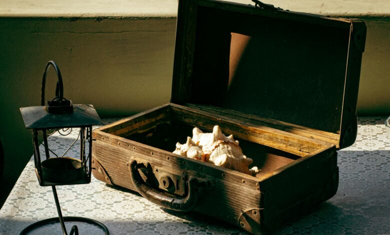 Discover a rustic setup with a vintage box, shells, and lantern on a lace-covered table.