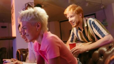 Three friends having a fun gaming session indoors, relaxed and smiling.