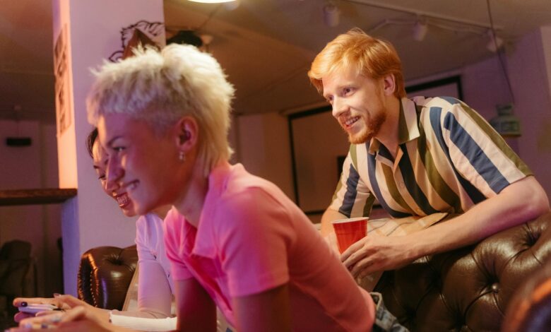 Three friends having a fun gaming session indoors, relaxed and smiling.