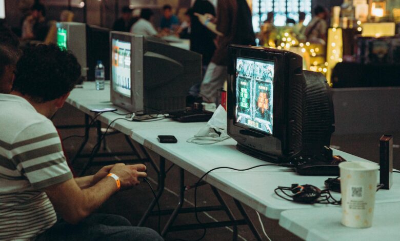 Adults enjoying a retro gaming event with CRT televisions and consoles, creating a nostalgic atmosphere indoors.