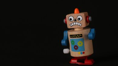 A vibrant wooden toy robot stands on a dark surface, showcasing vivid colors and playful design.