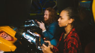 A couple immersed in playing arcade games together, showcasing fun and leisure in a vibrant setting.