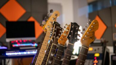 Close-up view of electric guitars lined up in a modern recording studio with vibrant acoustic panels.