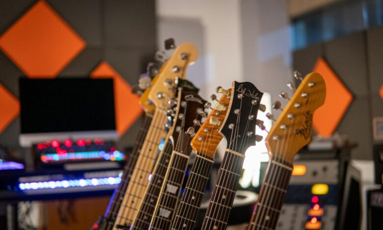 Close-up view of electric guitars lined up in a modern recording studio with vibrant acoustic panels.