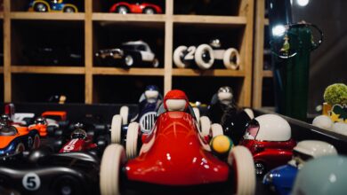 A vibrant assortment of miniature vintage race cars showcased in a wooden display case.