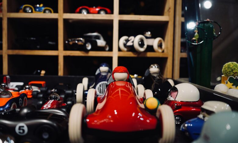 A vibrant assortment of miniature vintage race cars showcased in a wooden display case.