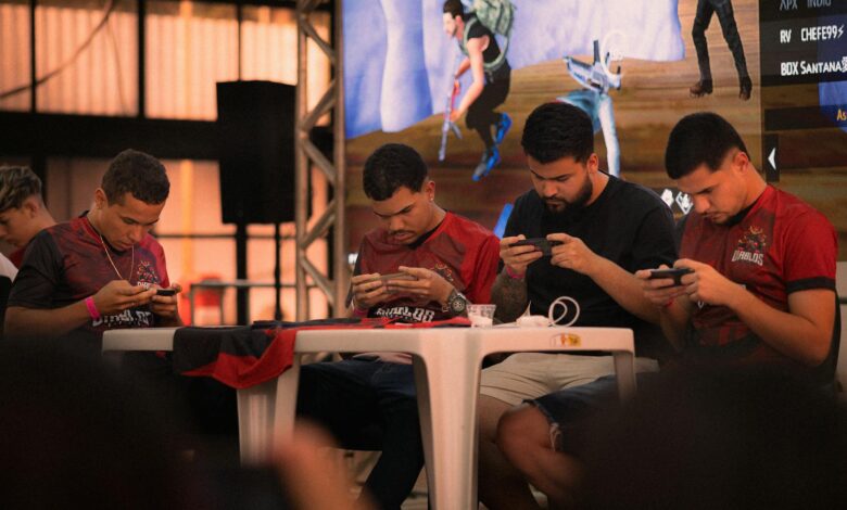 Group of gamers intensely focused during a mobile e-sports tournament indoors.