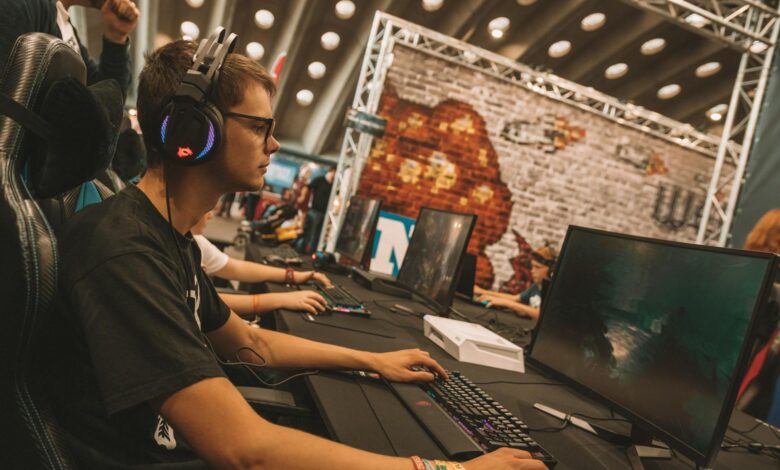 A young male gamer intensely focused during an esports event at an indoor gaming convention.