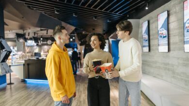 A group of friends enjoying popcorn and conversation in a modern cinema hallway.