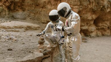 Two astronauts in space suits exploring a barren, rocky landscape. Sci-fi atmosphere.