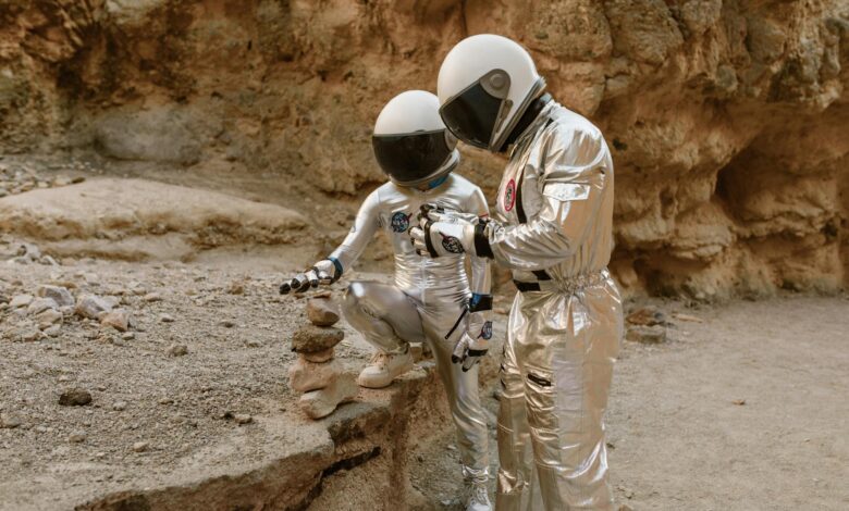 Two astronauts in space suits exploring a barren, rocky landscape. Sci-fi atmosphere.