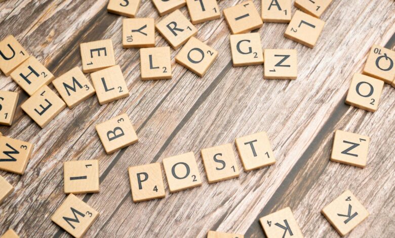 Wooden scrabble tiles scattered with the word 'POST' on a rustic wooden surface.