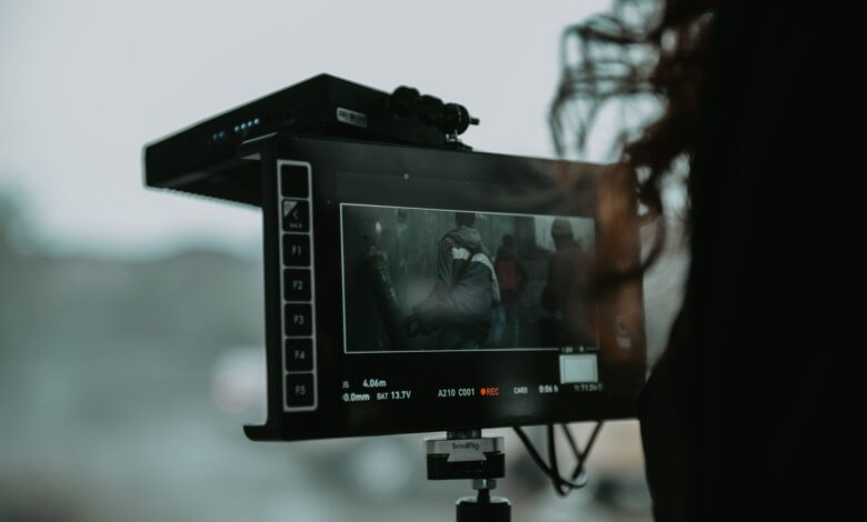 A close-up of professional filming equipment capturing a scene outdoors.