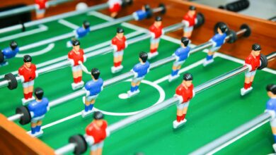 Vibrant foosball table game in play, showcasing red and blue teams in strategic setup.