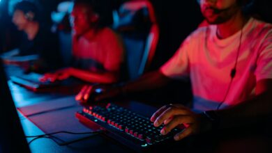 Diverse group of gamers focused on a competitive esports match in a dimly lit arena.