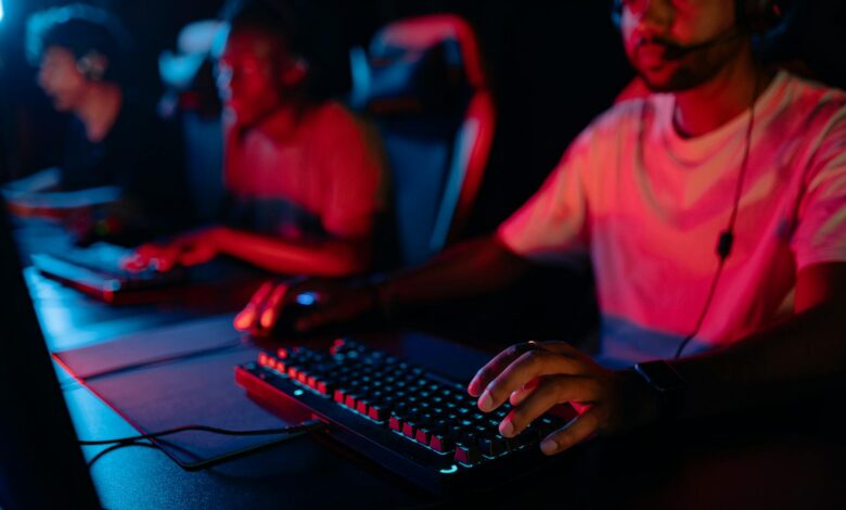 Diverse group of gamers focused on a competitive esports match in a dimly lit arena.