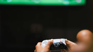 Close-up of hands holding a modern video game controller while gaming.