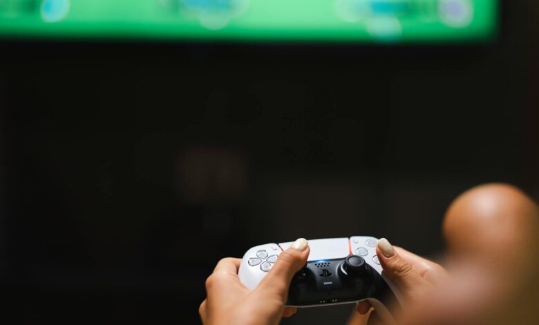 Close-up of hands holding a modern video game controller while gaming.