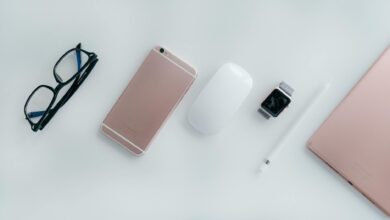 Elegant arrangement of glasses, phone, watch, mouse, pencil, and tablet on a white surface.