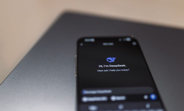 Close-up of a smartphone with AI assistant interface on screen over a laptop.