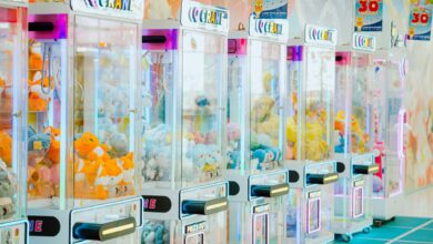 Colorful arcade claw machines filled with plush toys in a bright gaming center.