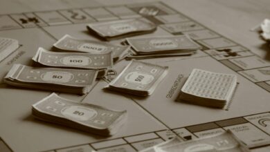 Close-up of board game with play money in sepia tone, focusing on strategic play.