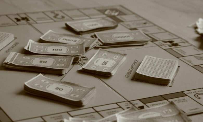 Close-up of board game with play money in sepia tone, focusing on strategic play.