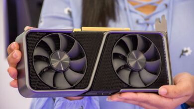 Detailed shot of hands holding a modern graphics card indoors.