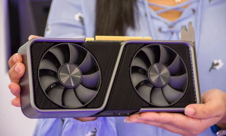 Detailed shot of hands holding a modern graphics card indoors.