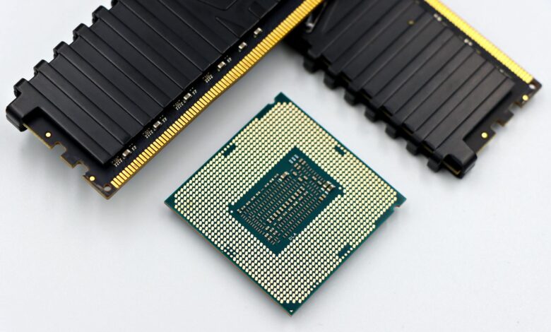 A CPU and RAM sticks displayed on a white surface, showcasing computer hardware components.