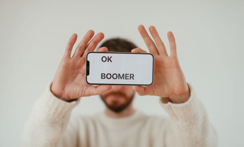 A man holding a smartphone with 'OK Boomer' text, emphasizing generational themes and internet culture.